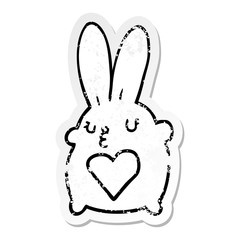 distressed sticker of a cute cartoon rabbit with love heart