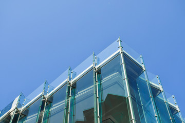 Frameless glass facade modern building, tempered laminated glass wall or curtain wall blue color,...