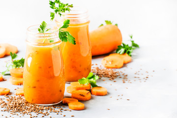 Carrot smoothie or juice with linen seeds, healthy and useful drink, gray background, selective focus