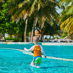Toddler boy in resort swimming pool