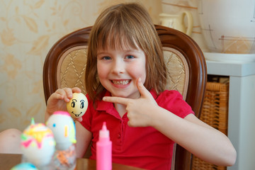 The girl is fun painting eggs for Easter