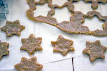 Raw cookies from gingerbread dough Overhead star shaped biscuit from fresh gingerbread dough placed...