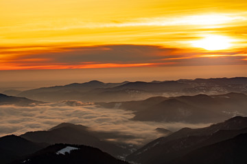 Mountain landscape with winter fog at sunse of Ceahlau, Romaniat