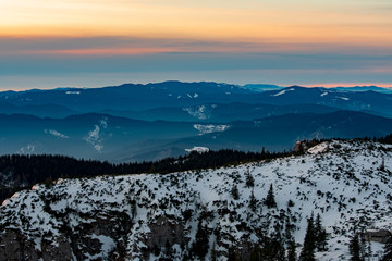 Mountain landscape with winter fog at sunse of Ceahlau, Romaniat