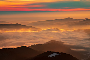 Mountain landscape with winter fog at sunse of Ceahlau, Romaniat