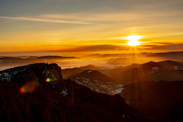 Mountain landscape with winter fog at sunse of Ceahlau, Romaniat