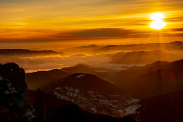 Mountain landscape with winter fog at sunse of Ceahlau, Romaniat
