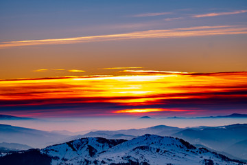 Mountain landscape with winter fog at sunse of Ceahlau, Romaniat