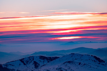 Mountain landscape with winter fog at sunse of Ceahlau, Romaniat