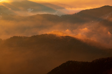 Mountain landscape with winter fog at sunse of Ceahlau, Romaniat