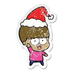 happy distressed sticker cartoon of a boy waving wearing santa hat