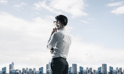 Concept of business success and control with confident boss against cityscape background