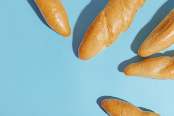 From above photo of french baguette bread on light-blue background. Copy spase.