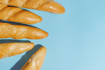 From above photo of french baguette bread on light-blue background. Copy spase.