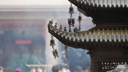 Immortal and beasts on the eaves of the building in Shanghai Jingan temple, Imperial yellow roof decorations, Wind bells under eaves sway with the wind, high speed video, slow motion. 
