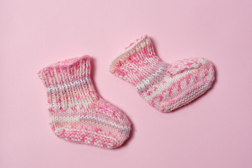 Children clothes concept on a white background. Pink knitted booties. Isolate