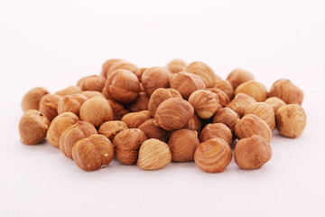 A pile of hazelnuts at white background