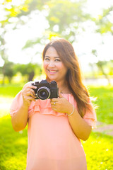 Young female photographer with a retro camera and smiling