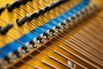 Pegs, damper and bass strings inside the old piano. The mechanism of musical instruments. Sound technology. Shallow depth of field