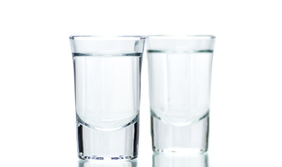 two glasses, shot glasses with liquid on a white background
