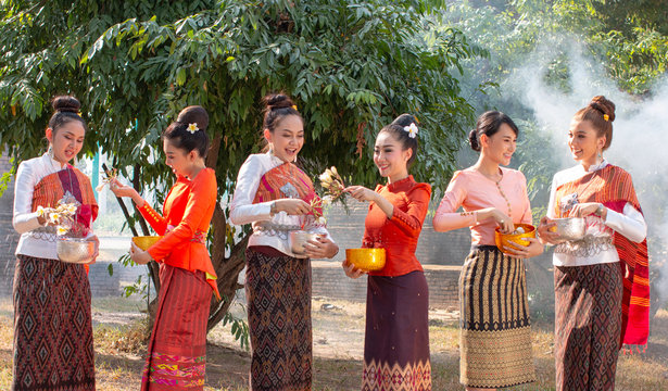 Beautiful Thai girl in Thai costume,Asian woman wearing traditional Thai culture at temple playing water in Songkran day water festival at Thailand.
