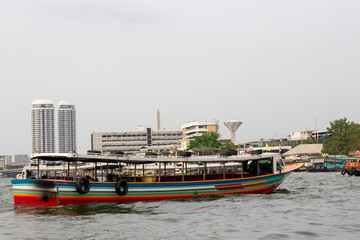 Fototapeta na wymiar The long-tailed boat is sailing on the Chao Phraya River through the city of Bangkok