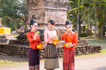 Beautiful Thai girl in Thai costume,Asian woman wearing traditional Thai culture at temple playing water in Songkran day water festival at Thailand.