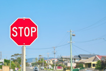 Stop sign with street and blue sky background