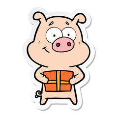 sticker of a happy cartoon pig holding christmas present