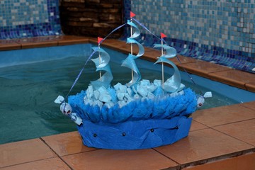 Model sailboat made of blue paper, filled with candy