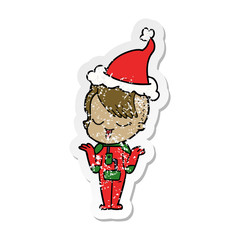 happy distressed sticker cartoon of a girl in space suit wearing santa hat