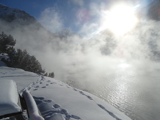 Fototapeta na wymiar lago di montagna con vapore e neve