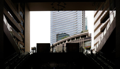 silhouette of fence, escalator and city office building