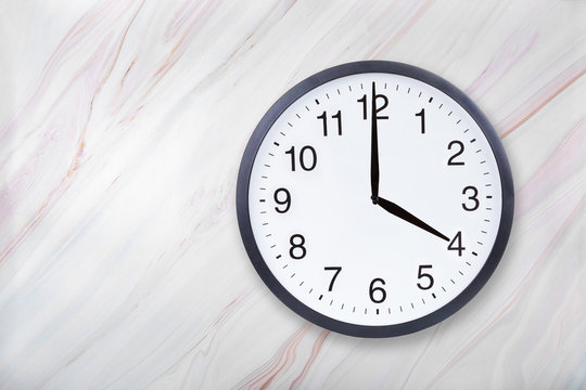 Wall clock show four o'clock on marble texture. Office clock show 4pm or 4am on marble texture with natural pattern