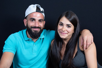 Happy young couple embracing in black background