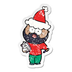 distressed sticker cartoon of a bearded man with clipboard and pen wearing santa hat