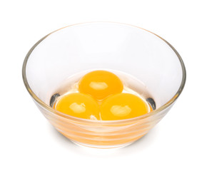 three egg yolk in a glass bowl isolated on white background with clipping path