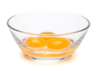 three egg yolk in a glass bowl isolated on white background with clipping path