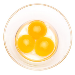 three egg yolk in a glass bowl isolated on white background with clipping path