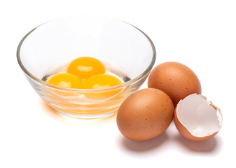 three egg yolk in a glass bowl and shell isolated on white background with clipping path