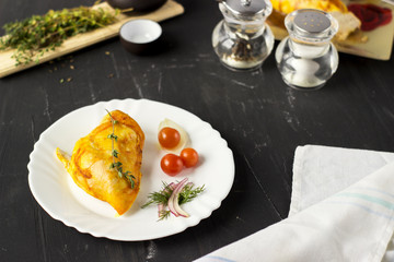 Baked chicken breast with onions and tomatoes on a white plate. Healthy food.