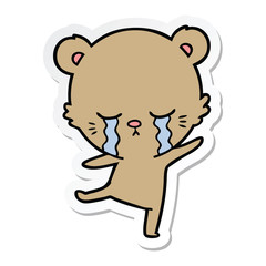 sticker of a crying cartoon bear balancing