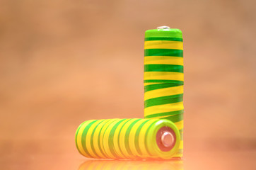 Two yellow-green batteries closeup on wooden background