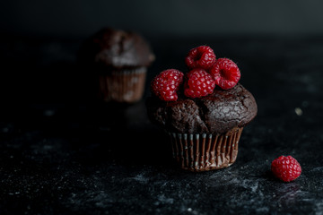 chocolate muffin with fresh raspberries in a rustic kitchen