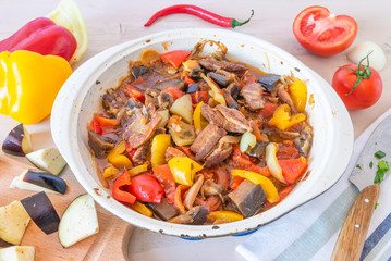 Stew with pork, eggplant and vegetables in a large frying pan