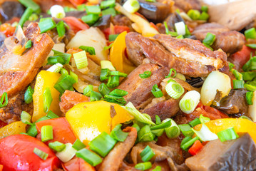 Stew with pork, eggplants, tomatoes and multicolored peppers close-up