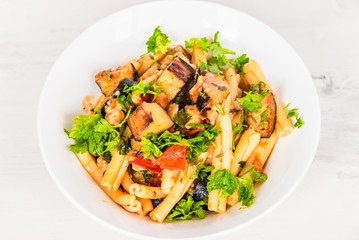 Rustic italian vegetarian pasta with fried eggplants and tomatoes.