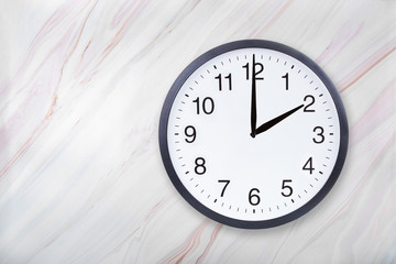 Wall clock show two o'clock on marble texture. Office clock show 2pm or 2am on marble texture with...