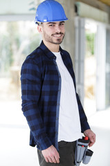 confident young male builder posing indoors