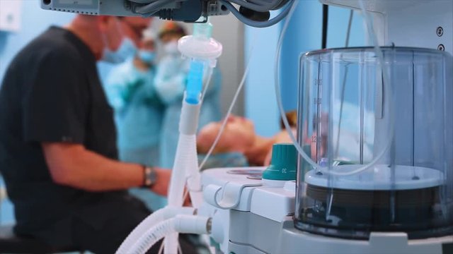 Operating room, patient preparation for surgery. Anesthesiologist with nurse prepares the patient for anesthesia view from the ventilator